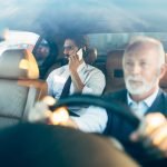 Young handsome business man sitting in his limousine. Business concept. Back light.
